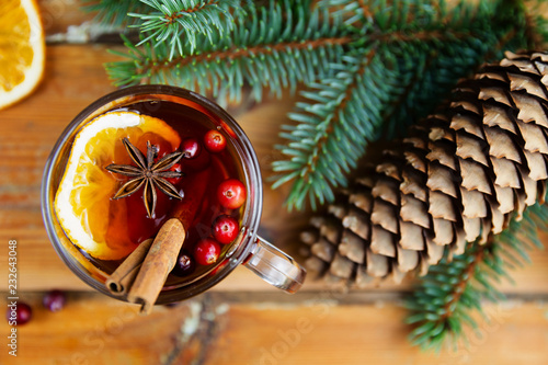 Christmas mulled wine with cinnamon, spices and orange slices on a wooden background. Winter hot drink
