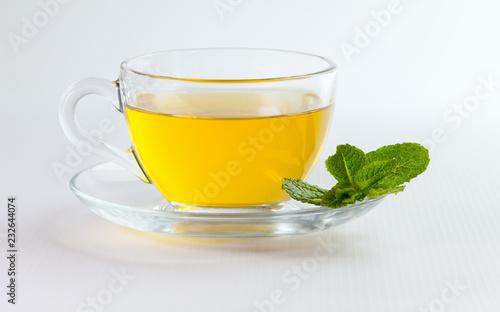 A cup of green tea with mint leaves