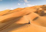 person in Liwa desert, part of Empty Quarter, the largest continuous sand desert in the world