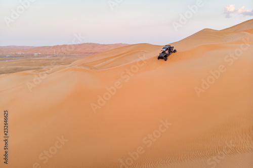 aeril view of Liwa desert, dune buggy driving down a dune