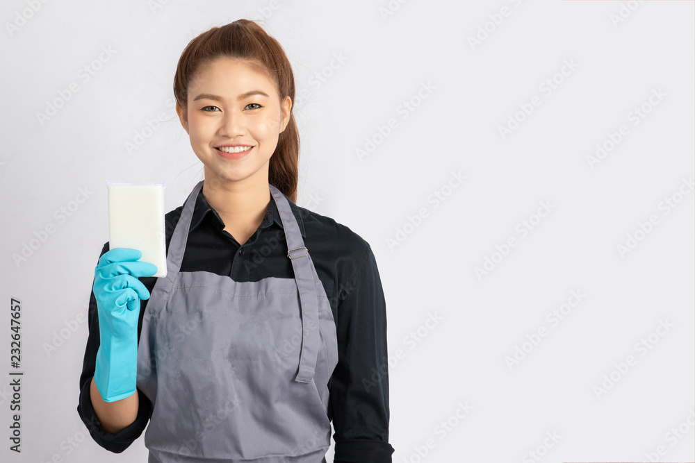 Beautiful Attractive Asian Maid smile and holding sponge for cleaning feeling so happiness and confident,Isolated on grey background,Maid Cleaning Service Concept Beautiful Attractive Asian Maid smile and holding sponge for cleaning feeling so happiness and confident,Isolated on grey background,Maid Cleaning Service Concept