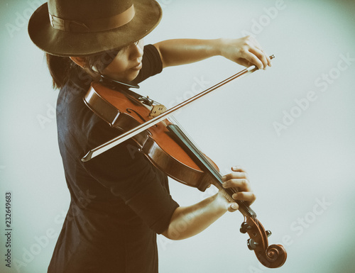 The labstract art design background of ady is playing violin,warm light tone,blurry light around photo