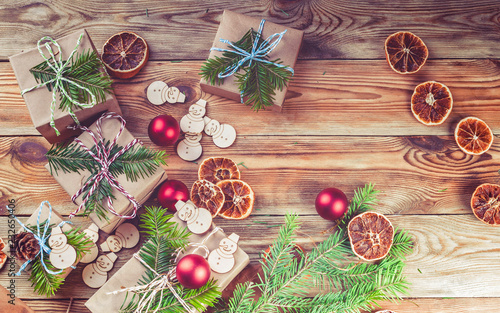 Christmas background. Christmas gifts, fir branches, cones and Christmas decorations on a wooden background. Top view