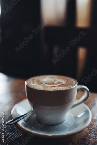 Cup of cappuccino on wooden table in cafe