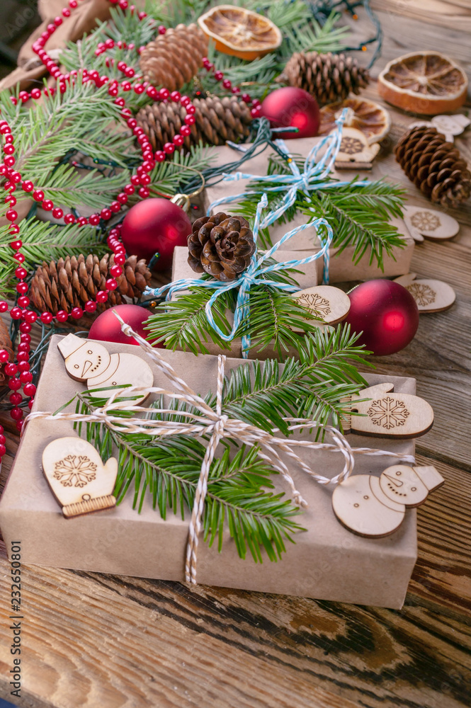 Christmas background. Christmas gifts, fir branches, cones and Christmas decorations on a wooden background. Vertical shot Christmas background. Christmas gifts, fir branches, cones and Christmas decorations on a wooden background. Vertical shot