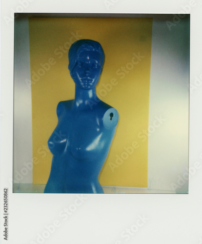 Polaroid scan of a blue mannikin torso in front of yellow and white background photo