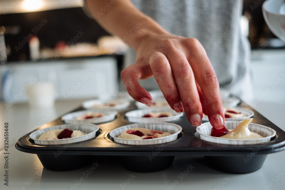 A young girl cooks in her kitchen. Bake cupcakes