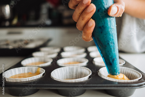 A young girl cooks in her kitchen. Bake cupcakes