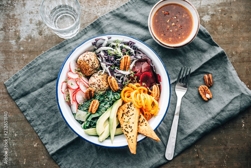 Food: healthy raw salad with quinoa balls and marinaded, fried t photo