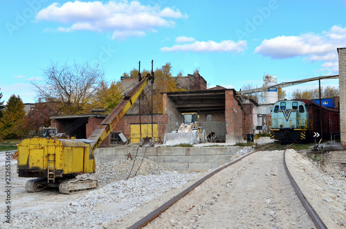 View of the industrial site of the plant for processing gypsum stone. Construction and special equipment  train with cars  excavator and bulldozer