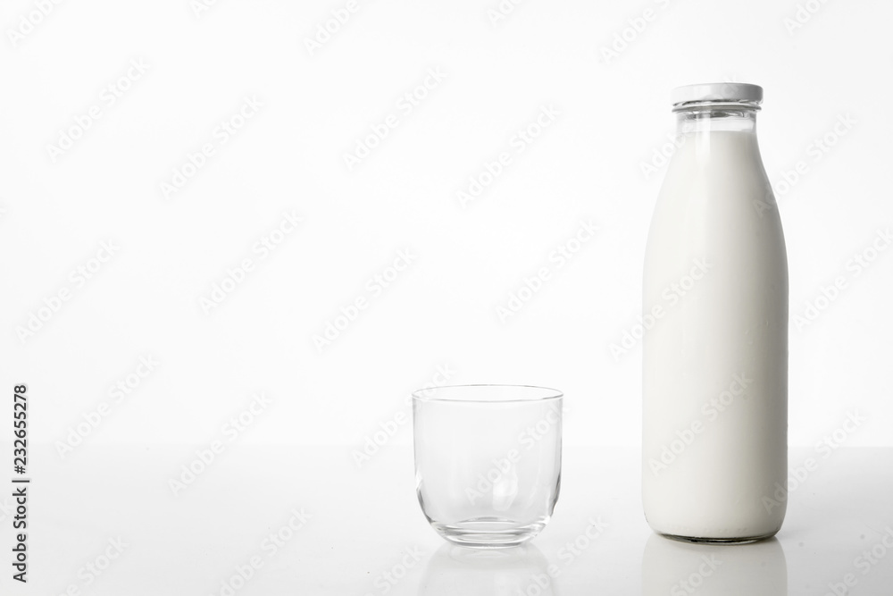 Photo of a bottle of milk and a glass on a white background. Photo of a bottle of milk and a glass on a white background.