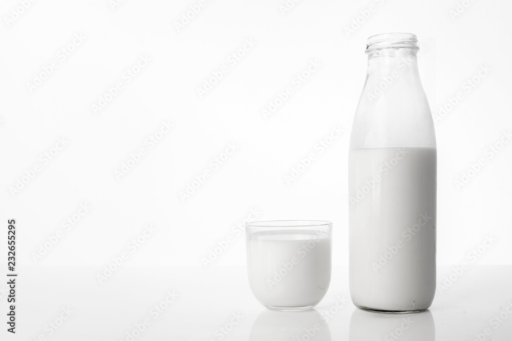 Photo of a bottle of milk and a glass on a white background. Photo of a bottle of milk and a glass on a white background.