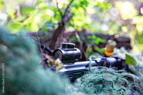 special forces, soldier assault rifle with silencer, optical sight. behind cover waiting in ambush photo