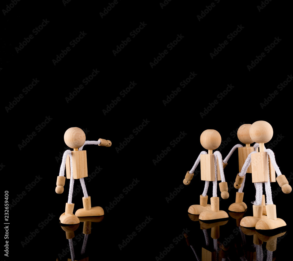 Teamwork and team leader pointing at the right direction. Wooden Stick Figures Team, isolated on black background, copy space Teamwork and team leader pointing at the right direction. Wooden Stick Figures Team, isolated on black background, copy space