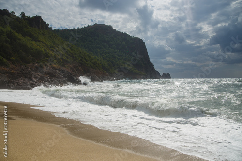 View over the blue stormy sea, nd castle hill in Alanya, Kleopatra beach Mediterranean Turkey