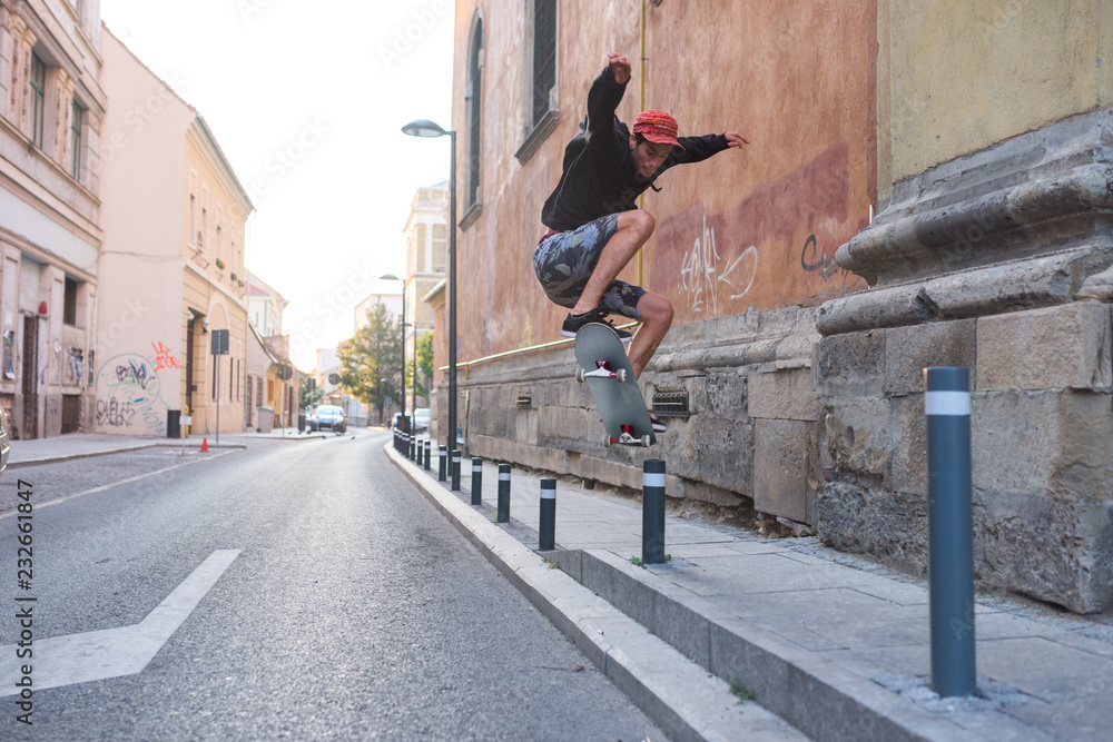 Teenager doing midair tricks with skateboard in urban scene