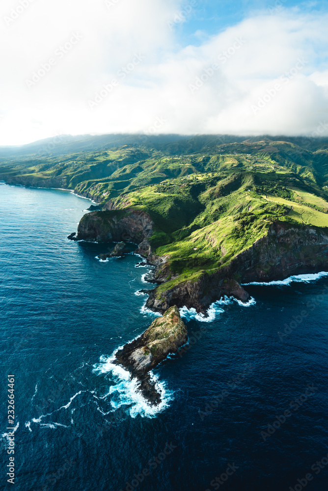 Beautiful Aerial View of Tropical Island Paradise Nature Scene of Maui Hawaii On Clear Sunshine Blue Sky Day with Vibrant Blue Ocean Water and Waves and Lush Green Mountain Scenic Landscape 