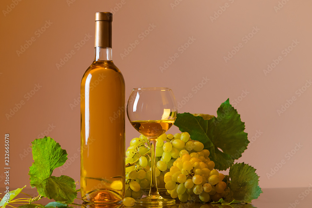 Wine. Bottle and a glass of white wine with ripe grapes still life. White wine on a dark background. Border art design.
