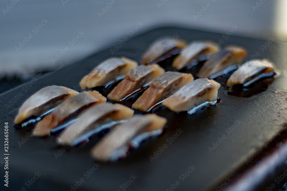 Sliced fish on a black metal surface Sliced fish on a black metal surface