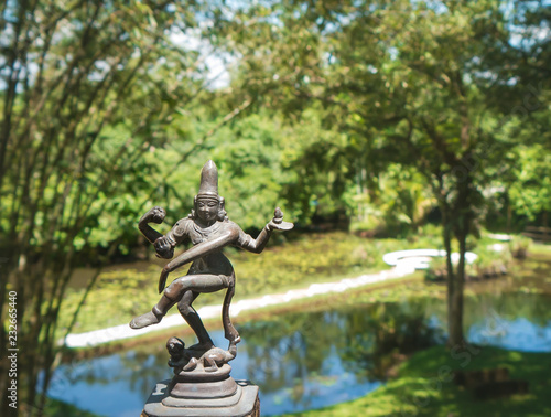 Antique statue of a dancing Buddha on the background of green nature. Sri lanka.