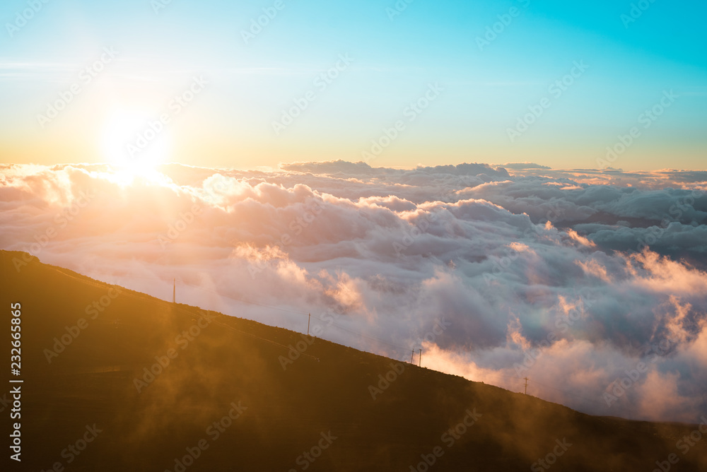 Beautiful Colorful Sunrise Sky at Dawn from the Top of Haleakala Volcano in Maui Hawaii High on Mountain Top with Sun Rays Through the Clouds of Amazing Landscape in Island Paradise