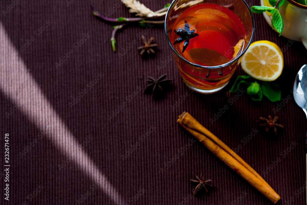 Oriental tea on a brown cloth Mat with spices and lemon. Lemon, mint, ginger, cinnamon. Oriental tea on a brown cloth Mat with spices and lemon. Lemon, mint, ginger, cinnamon.