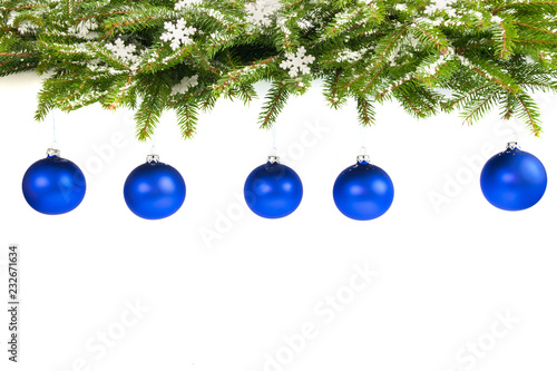 Hanging red baubles on the branches of a Christmas tree.