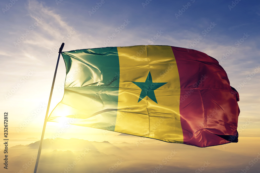 Senegal senegalese flag textile cloth fabric waving on the top sunrise mist fog