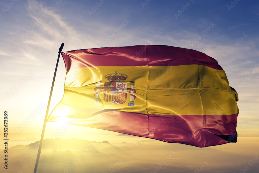 Spain spanish flag textile cloth fabric waving on the top sunrise mist fog