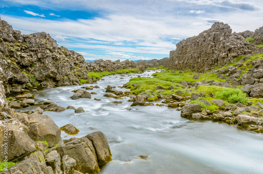 A smooth river inside the middle Atlantic ridge at thingvellir. A well-known location in the golden circle in Iceland. The only place on earth where the dosal rises above the earth
