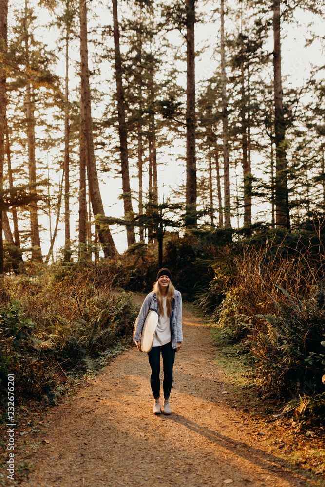 young woman in the forest with surfboard young woman in the forest with surfboard