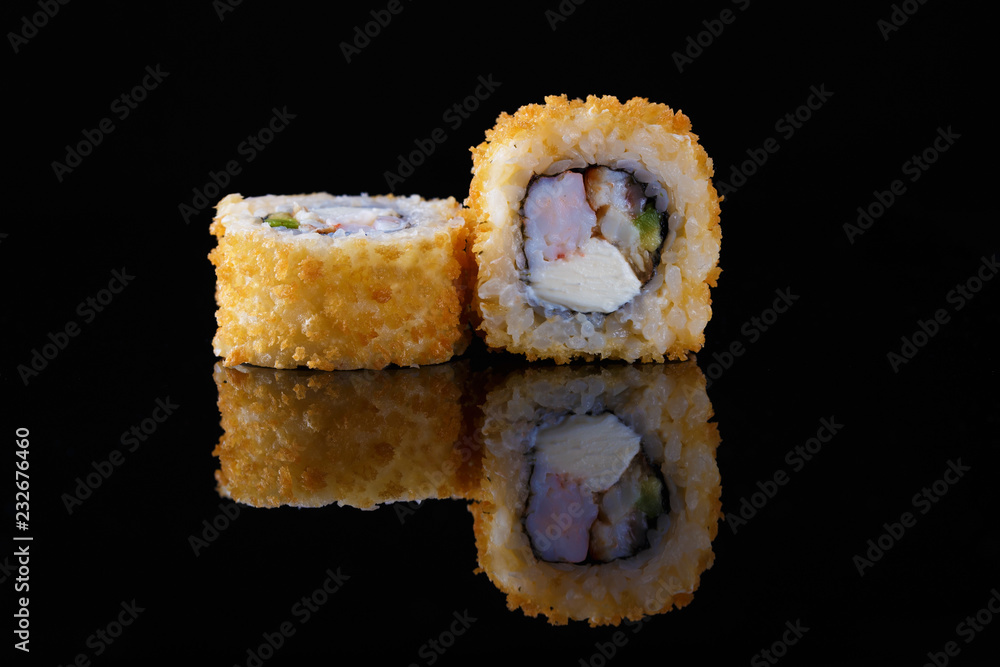 appetizing baked sushi roll with fish on a black background with reflection appetizing baked sushi roll with fish on a black background with reflection