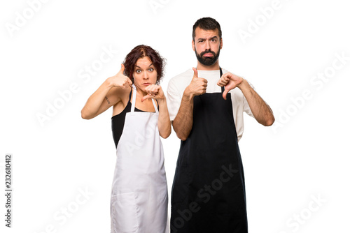 Couple of cooks making good-bad sign. Undecided between yes or n on isolated white background