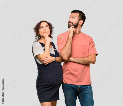 Couple with pregnant woman thinking an idea on isolated grey background