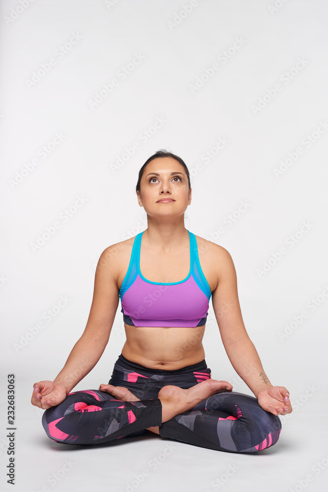 Woman sitting in yoga Padmasana, lotus pose Woman sitting in yoga Padmasana, lotus pose