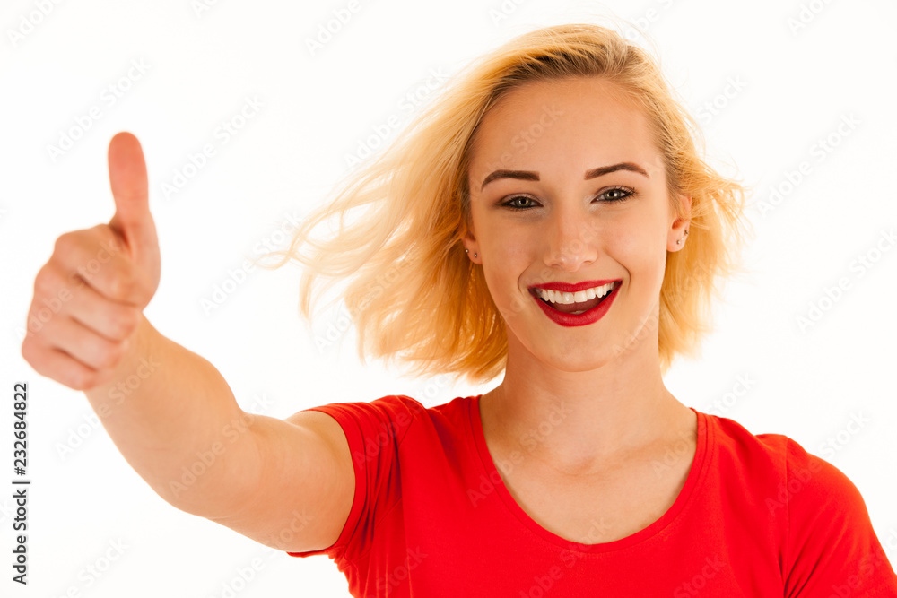 Attractive blonde woman shows thumb up as a gesture for success isolated over white background Attractive blonde woman shows thumb up as a gesture for success isolated over white background