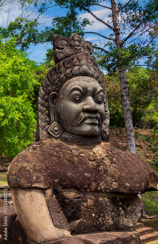 Stone carved statue Asura as guardian on right side bridge of South gate of Angkor Thom near Bayon temple in Siem Reap, Cambodia. Popular tourist attraction