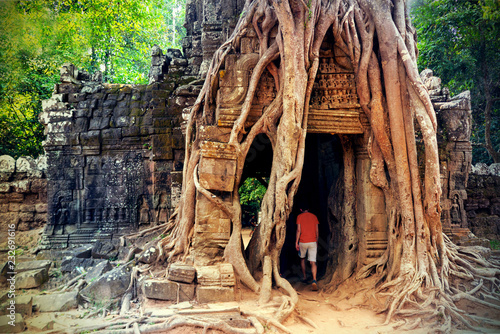 Huge roots of strangler fig tree on lost ancient temple Ta Som Gate in Angkor Wat complex at Siem Reap, Cambodia. Khmer architecture of Angkor Archaeological Park. UNESCO World Heritage site. photo