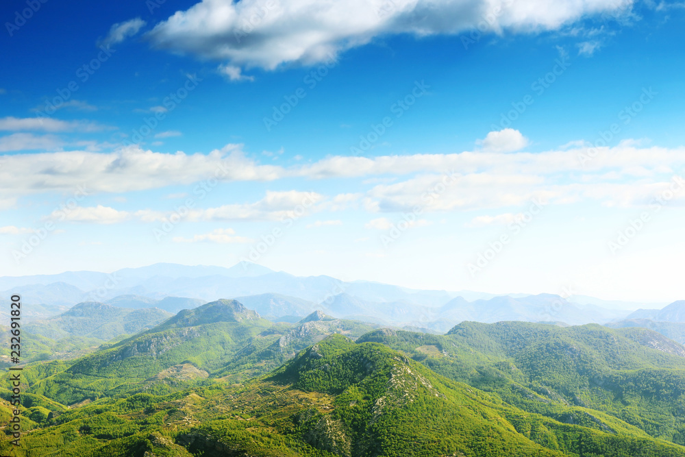 Landscape with green mountains and blue sky with clouds