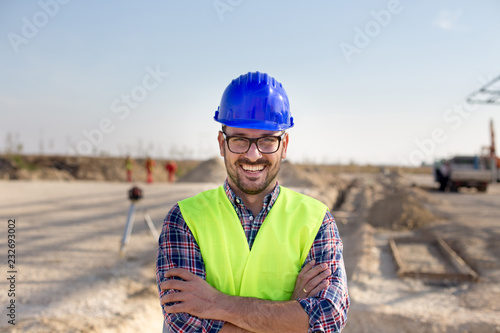 Engineer with crossed arms on building site photo