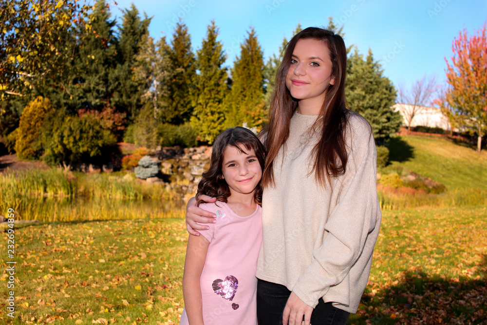 Close up, Portrait, Two Beautiful Happy Sisters, in the park in the open air, Golden Autumn Background Close up, Portrait, Two Beautiful Happy Sisters, in the park in the open air, Golden Autumn Background