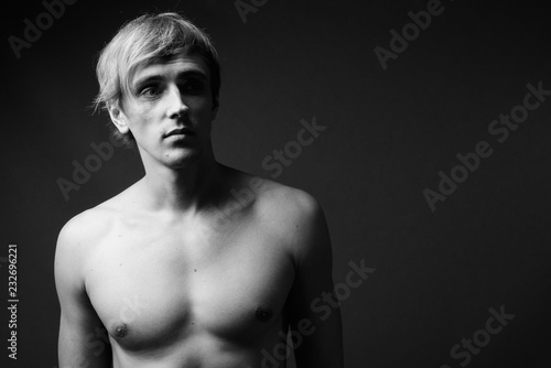 Young handsome man with blond hair shirtless in black and white