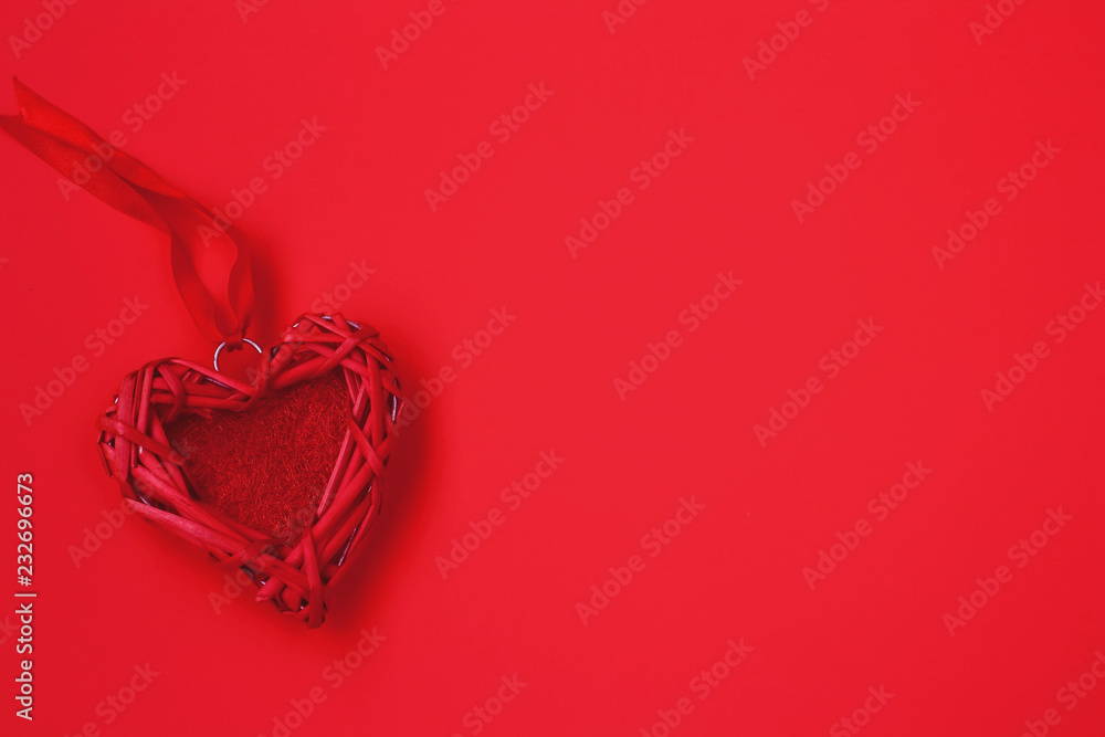 Valentine wicker heart, ribbon, red background. Valentines day composition