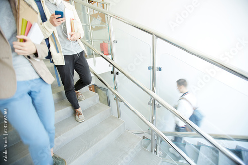 Фотография College students in casualwear going downstairs after lesson to have lunch