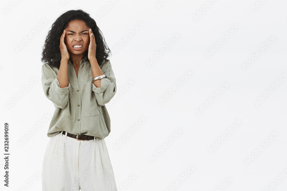 Woman cannot concetrate on work suffering headache. Bothered displeased businesswoman workaholic squinting and clenching teeth from pain holding fingers on temples feeling discomfort of migraine Woman cannot concetrate on work suffering headache. Bothered displeased businesswoman workaholic squinting and clenching teeth from pain holding fingers on temples feeling discomfort of migraine