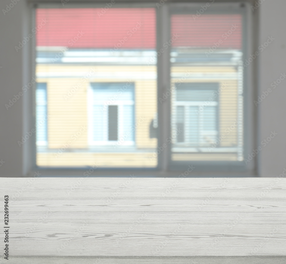 Fototapeta premium Wooden table in front of window with shutters indoors