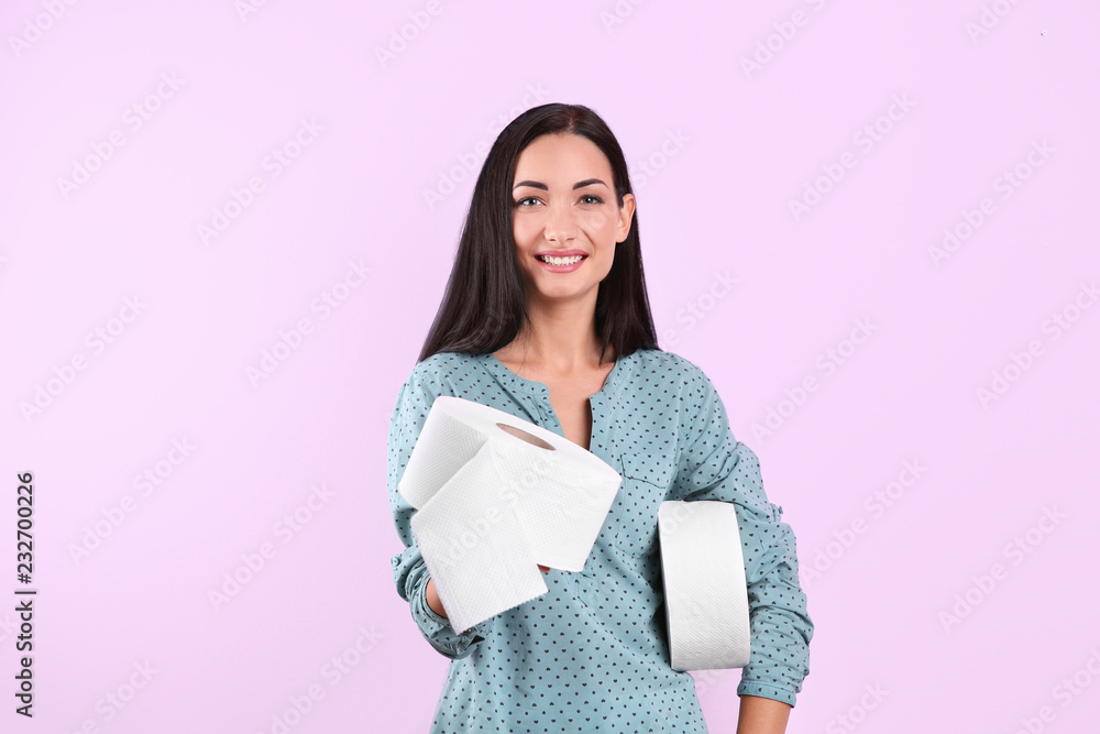 Beautiful woman holding toilet paper rolls on color background Beautiful woman holding toilet paper rolls on color background