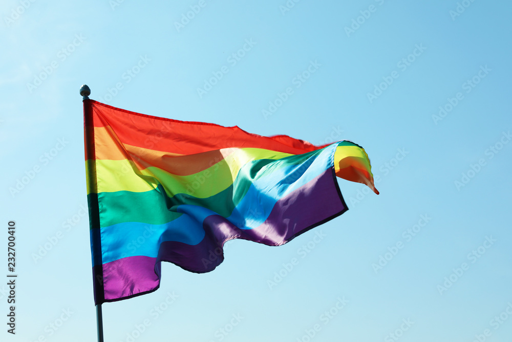Rainbow gay flag against blue sky. LGBT concept