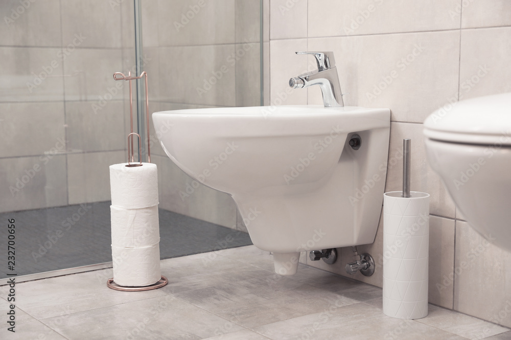Holder with toilet paper rolls on floor in bathroom Holder with toilet paper rolls on floor in bathroom