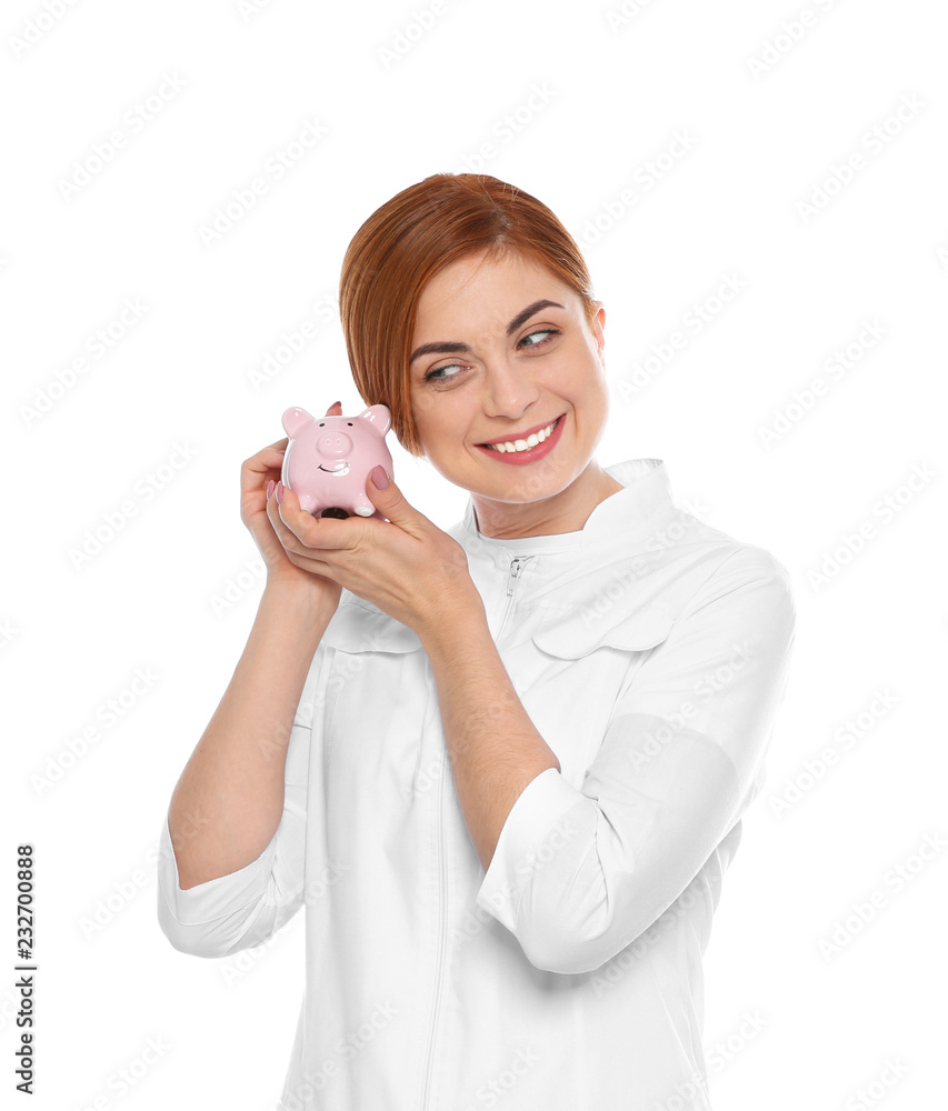 Portrait of female doctor with piggy bank on white background